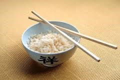 chopsticks on a porcelain bowl with rice.